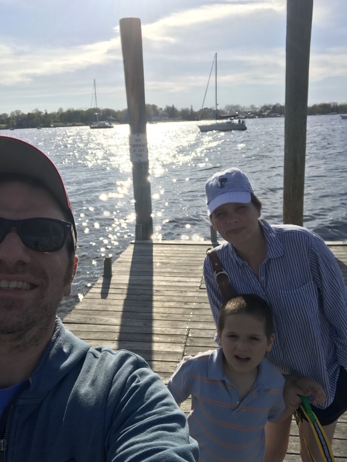 Our family together on a wooden dock in Bristol, with sailboats and sunlight across the harbor.