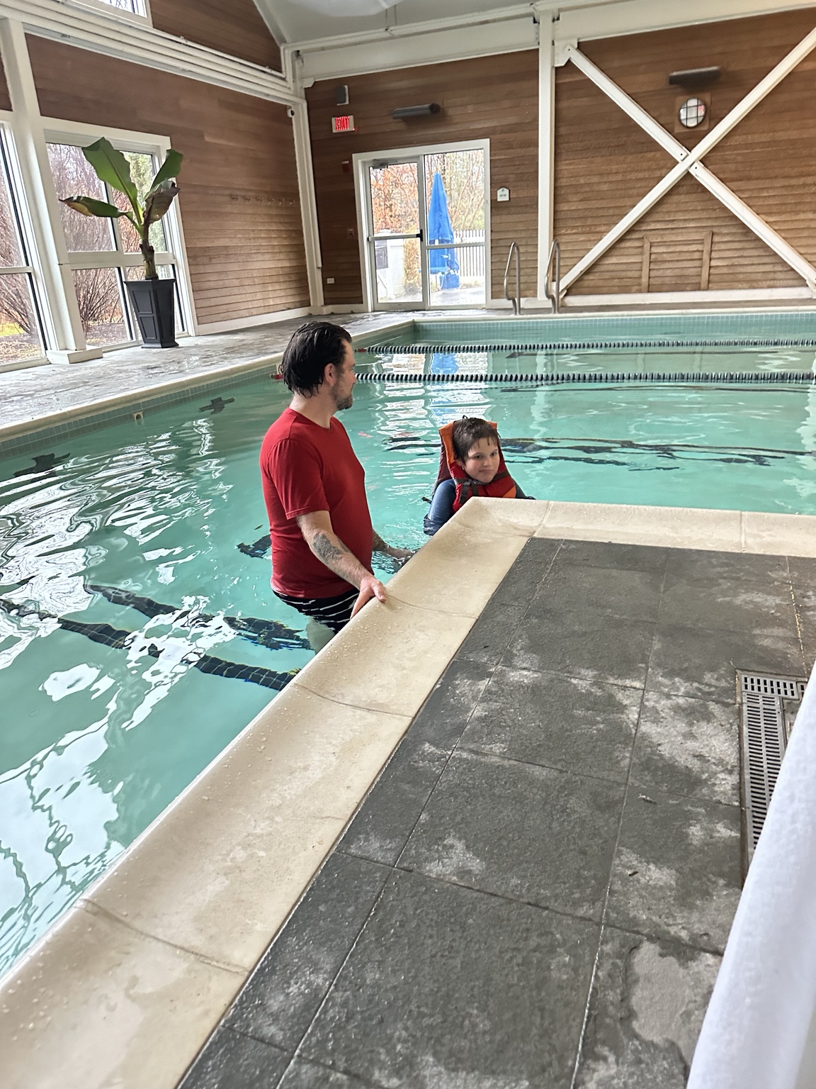 James wearing his life jacket beside his dad in the indoor pool at The Essex Resort.