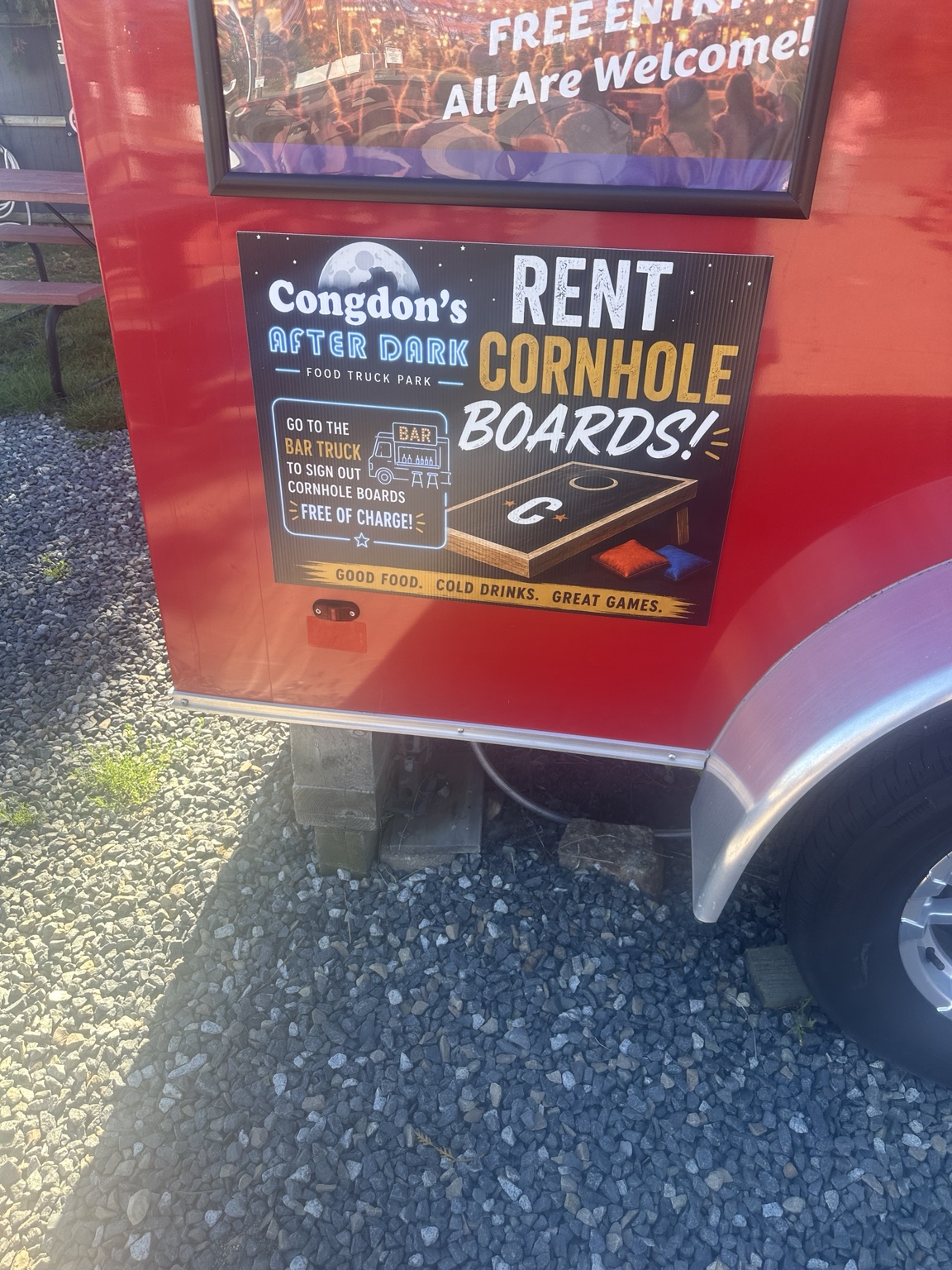 An After Dark sign advertises cornhole boards that can be signed out at the bar truck free of charge.