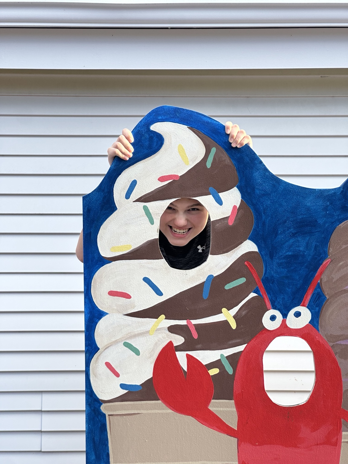 James smiling through the ice-cream cone cutout at Dairy Joy in Weston.