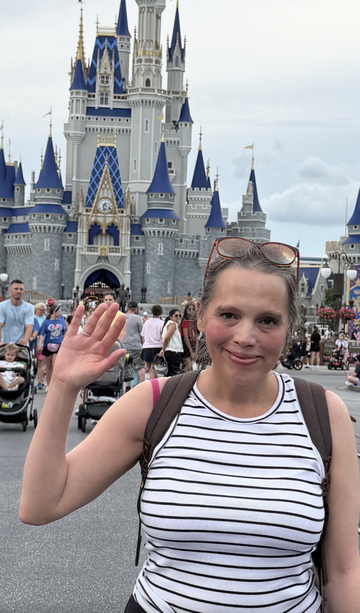 Hannah in a striped top in front of Cinderella Castle.