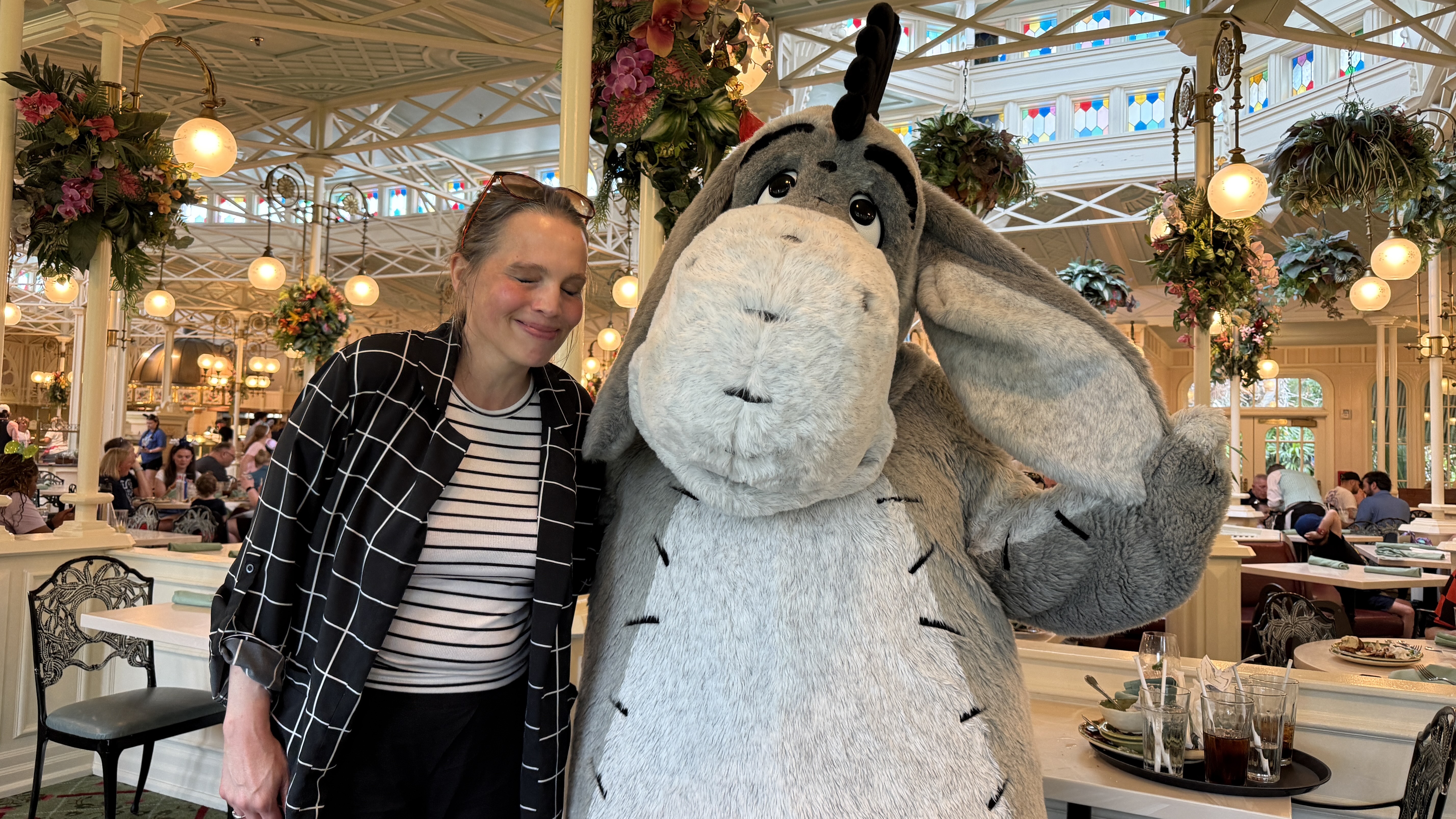 Hannah beside Eeyore in the bright Crystal Palace dining room.