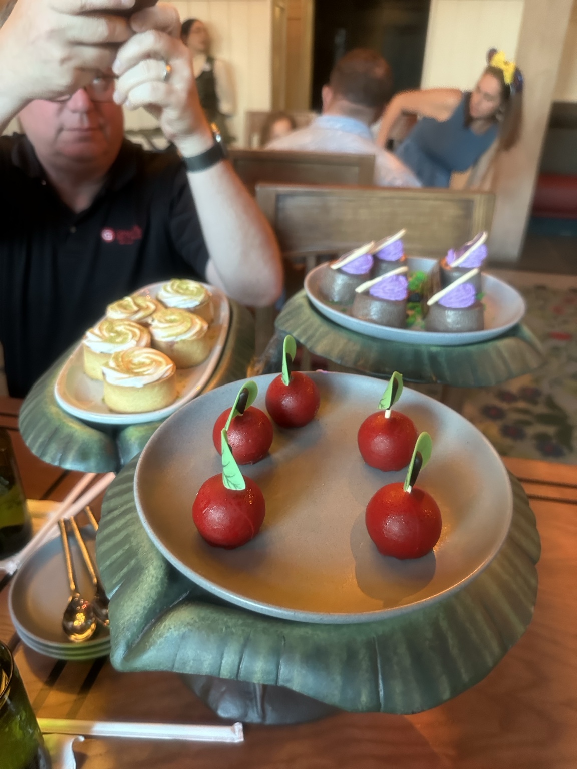 Small red apple-shaped desserts on a woodland-themed serving display.