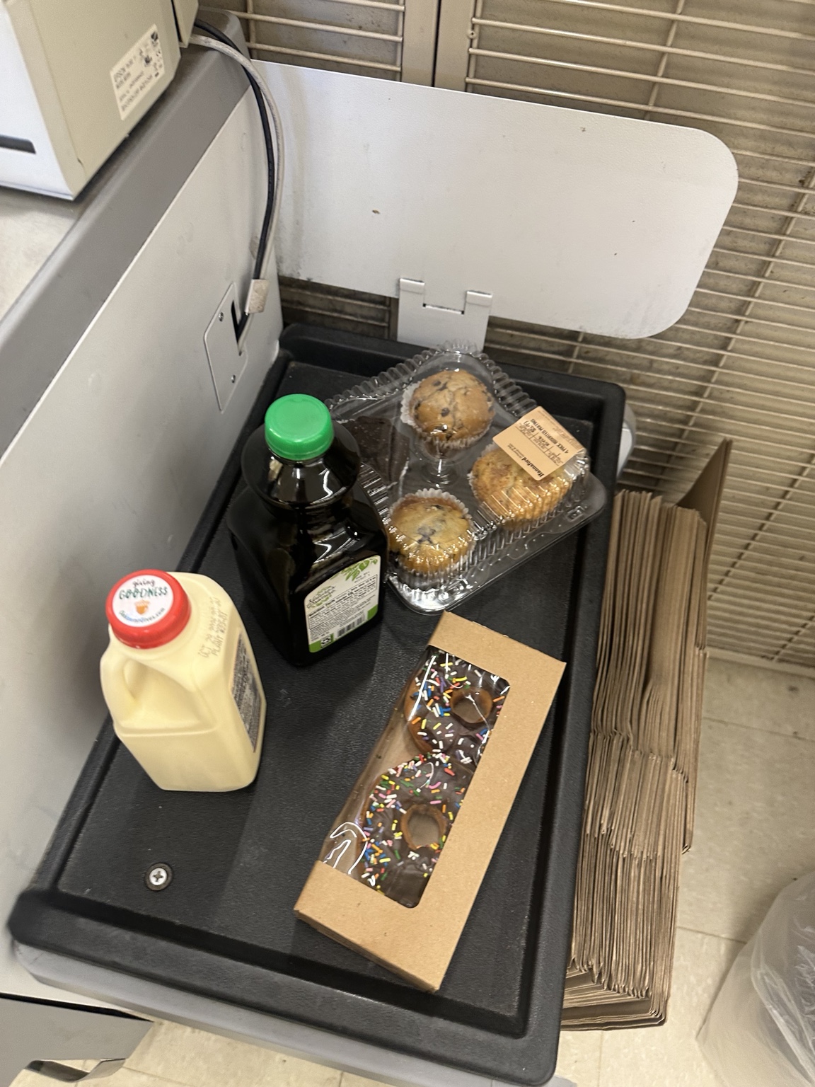 Oakhurst eggnog, bottled cold brew, a four-pack of assorted muffins and chocolate-frosted donuts with sprinkles at a Hannaford self-checkout.