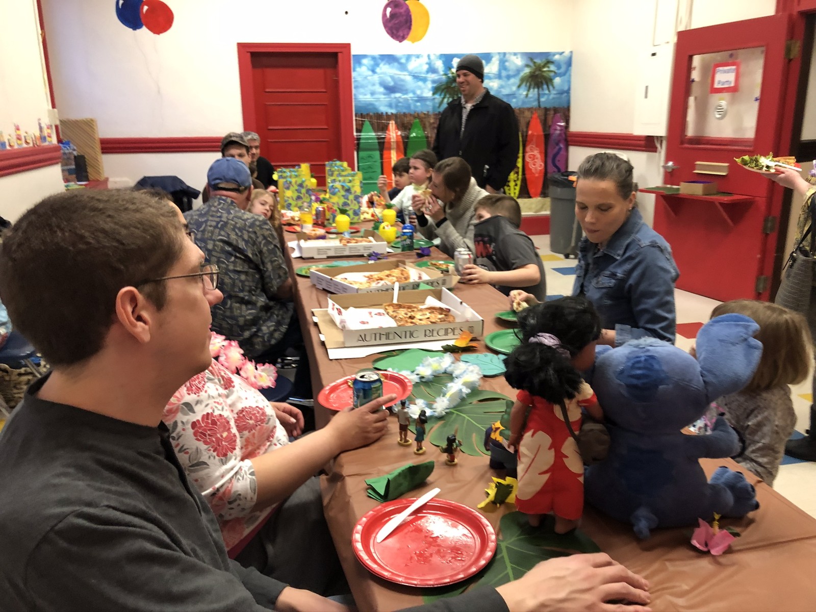 Family and friends gathered around the decorated party table at the museum.