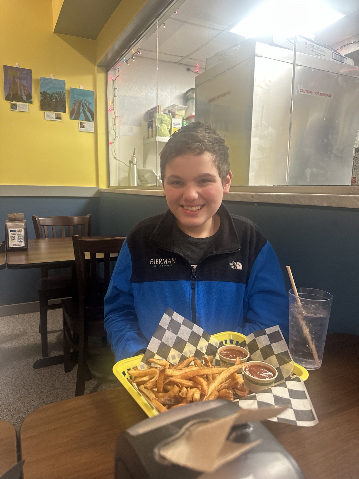 James smiling at the table with a basket of fries at Omar’s Bistro.