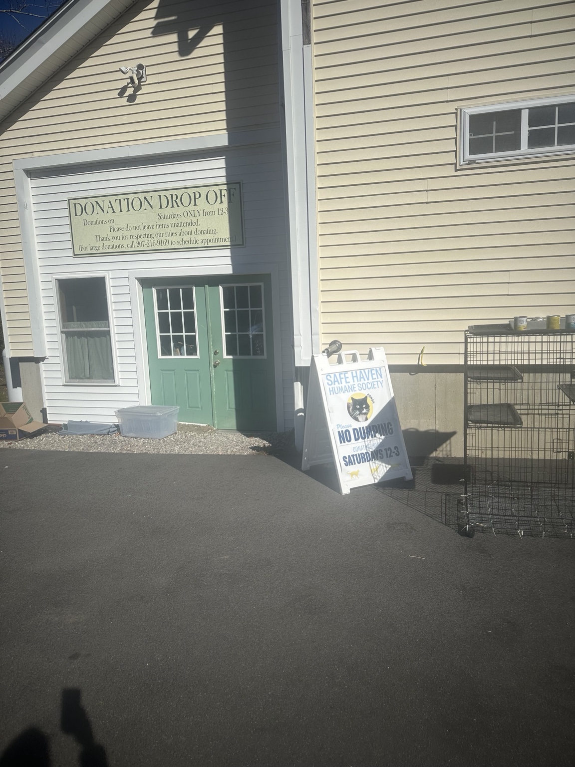 The donation entrance at Safe Haven, with signs listing Saturday receiving from noon to 3 p.m. and asking donors not to leave goods unattended.