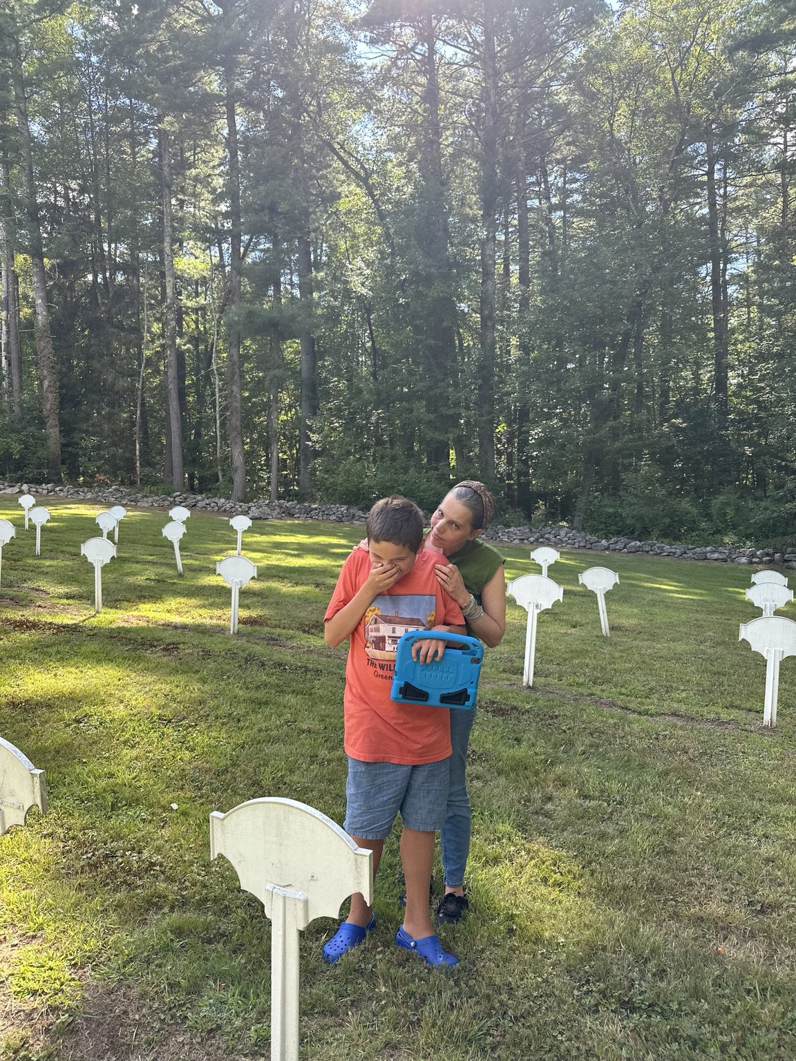 James and his mother together among white grave markers, stone walls and trees at the Shaker burial ground in Harvard, Massachusetts.
